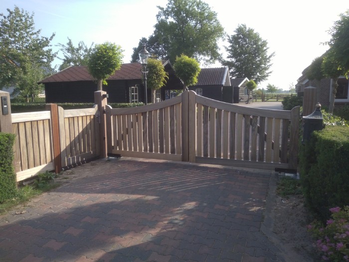 Houten toegangspoort binnen een landelijke omgeving.